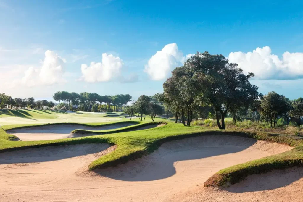 Sand traps at El Prat, surrounded by trees and grass